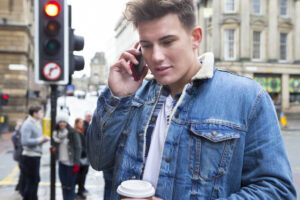 man on cell phone on street blue jacket deposit photo 3 29 22
