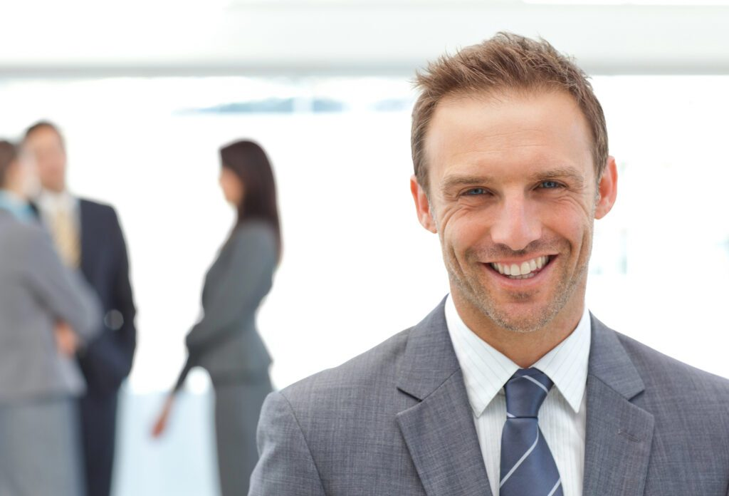 man in business suit smiling with tie