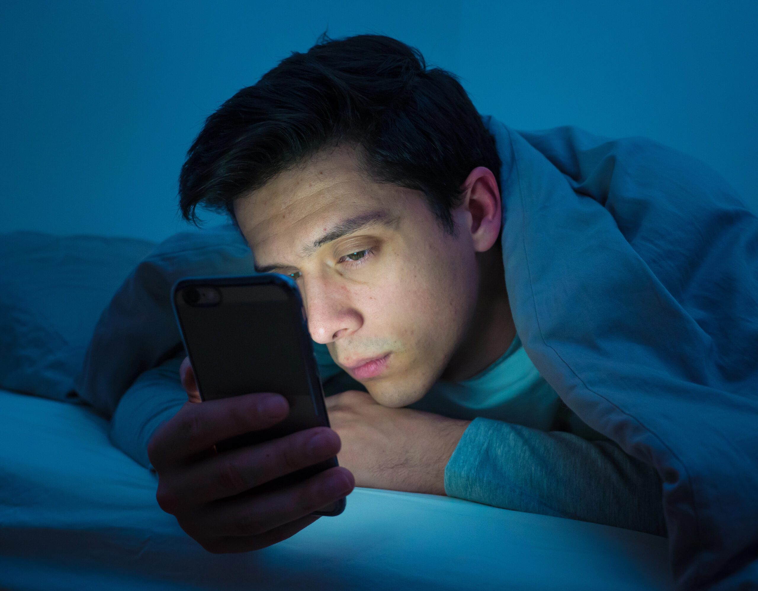 gay man alone at night looking at phone