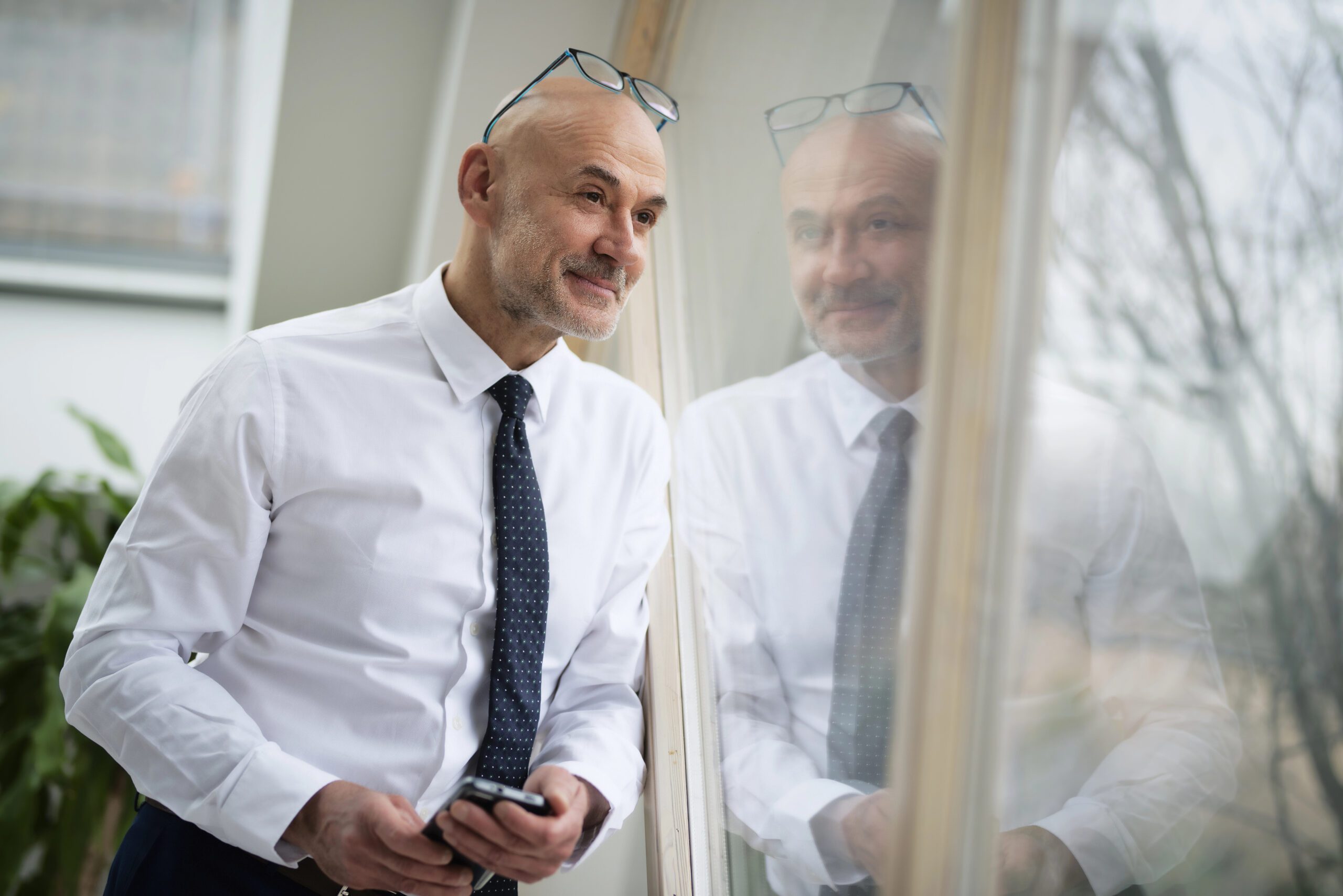 A gay businessman looking out the window.