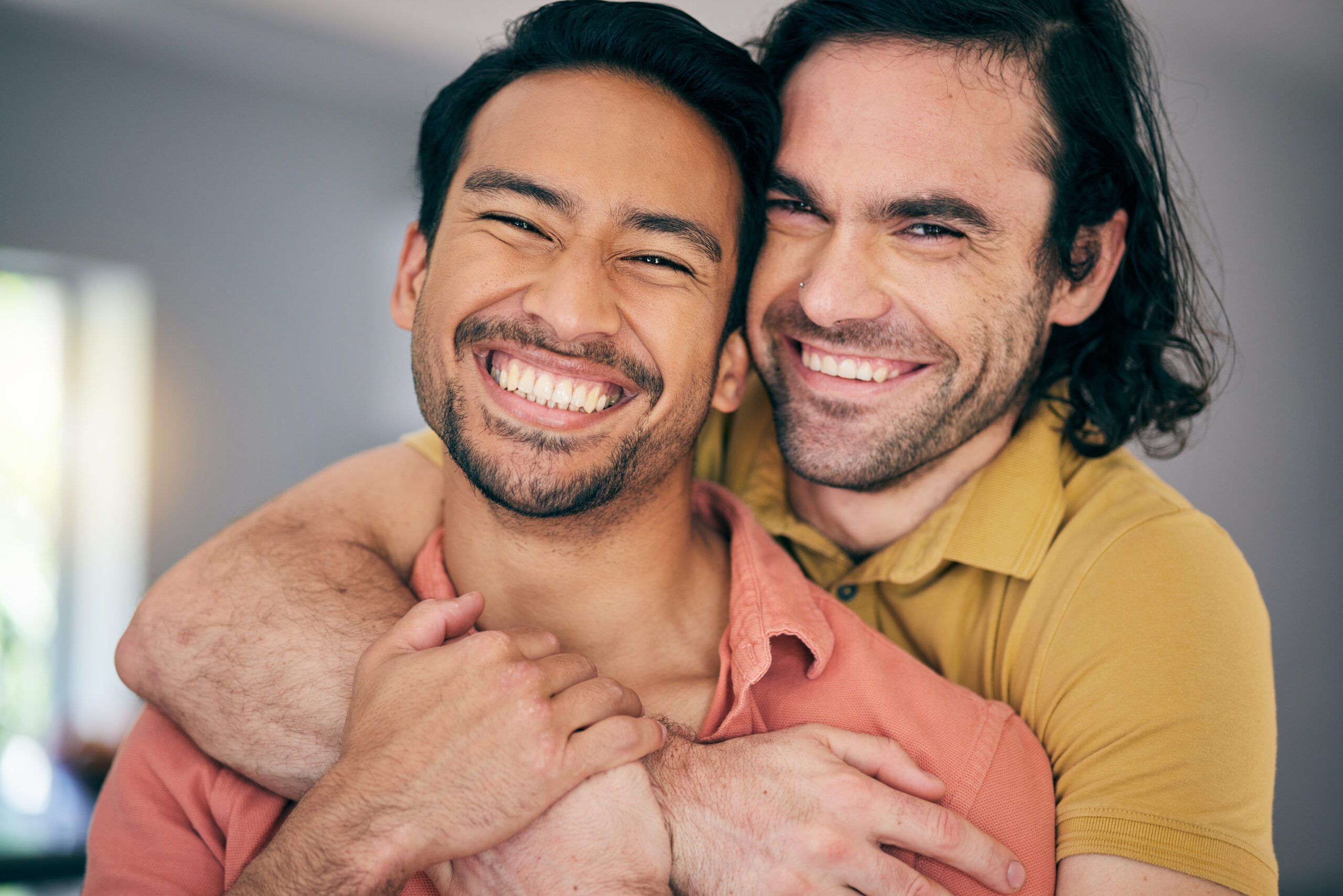 Two adult gay men sharing affectionate physical closeness at home